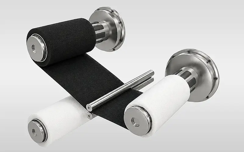 Materialbahnen werden zwischen Rollen zusammengeführt