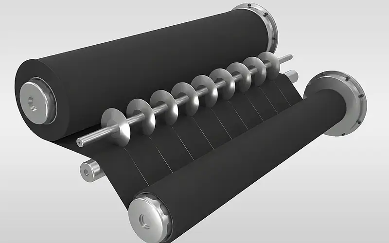 Schwarze Elastomerbahn läuft über Walzen an Schneidmessern vorbei