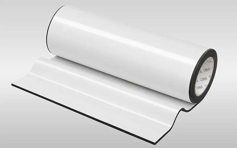 Aufgerollter selbstklebender Schaumstoffverbund als Beispiel für eine zu prüfende Materialkombination