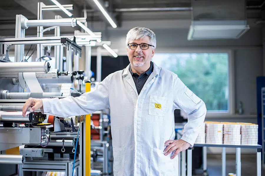 Mitarbeiter in Arbeitskleidung an einer Fertigungsanlage